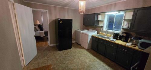 a small kitchen with a refrigerator and a sink at 3 Bedroom Retreat with Modern Comforts and Local Charm in Port Arthur