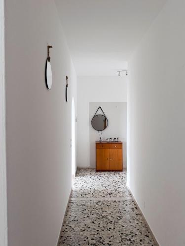 a hallway with white walls and a mirror on the wall at Casa Lagò Lagò Panoramic Apartment in Ranzanico