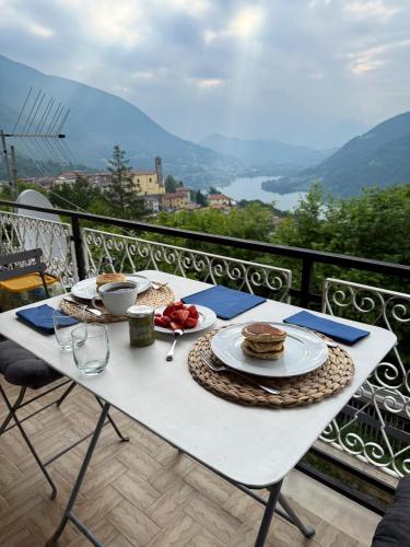 a white table with plates of food on a balcony at Casa Lagò Lagò Panoramic Apartment in Ranzanico