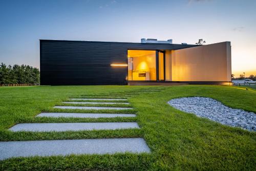 a house with a stone path in the yard at Beach Villa v Penati Golf Resort in Šajdíkove Humence