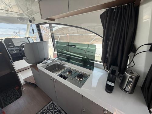 une vue intérieure d'une cuisine de camping-car avec un évier dans l'établissement Hébergement bateau à quai, à Saint-Mandrier-sur-Mer