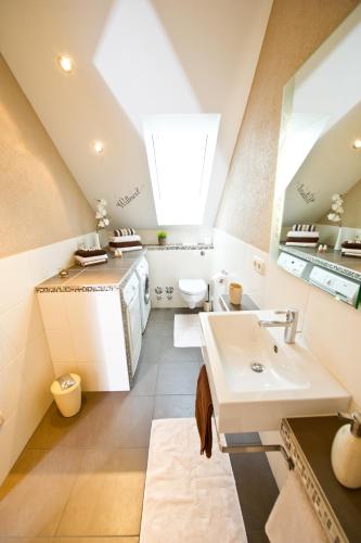 an attic bathroom with a sink and a toilet at Design-Wohnungen by Ulrike Horster in Bensheim