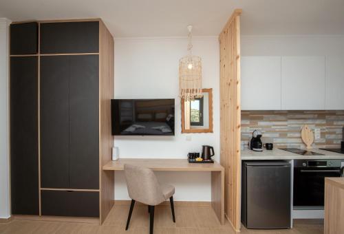 a kitchen with a table and a chair and a counter at Esperos Panoramic View Suites in Mytakas
