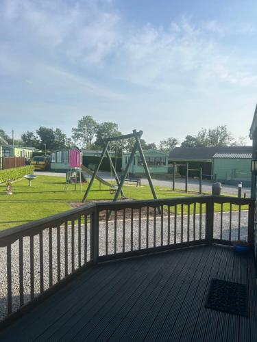 a playground with a swing set in a park at West Lakes Affordable Caravan in Lamplugh