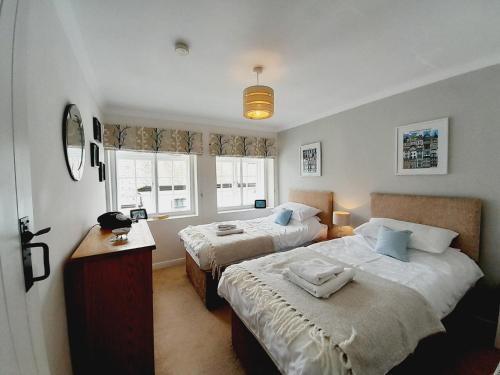 a bedroom with two beds and a window at Crab Cottage in Ilfracombe