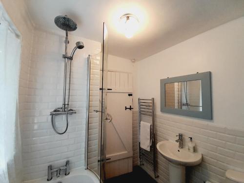 a bathroom with a shower and a sink and a tub at Crab Cottage in Ilfracombe