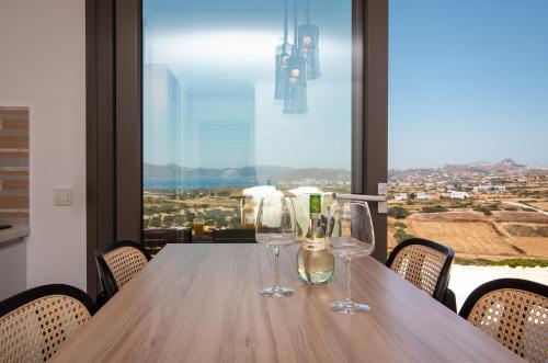 a wooden table with two wine glasses on it at Esperos Panoramic View Suites in Mytakas