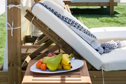 a plate of fruit on a table next to a chair at Esperos Panoramic View Suites in Mytakas