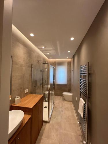 a bathroom with a sink and a shower and a toilet at Ramò Apartments in Canicattì