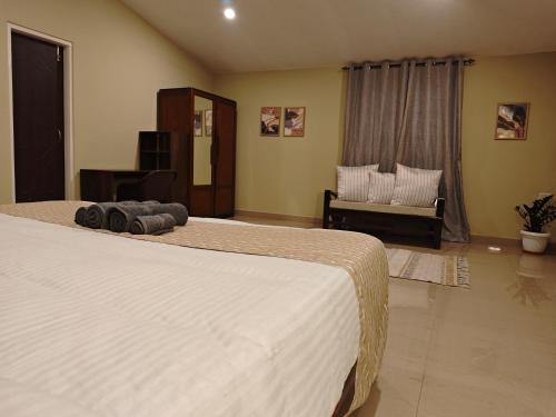 a bedroom with two beds and a couch in it at The Camellia in Jorhat