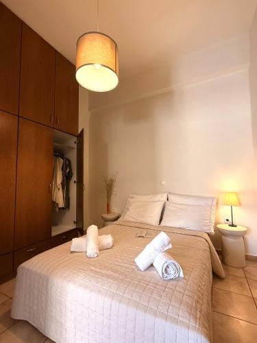 a bedroom with a large bed with towels on it at Nostos Apartment Galatas in Galatas