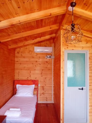 a small room with a bed and a door at Wooden Villas Karme in Koman