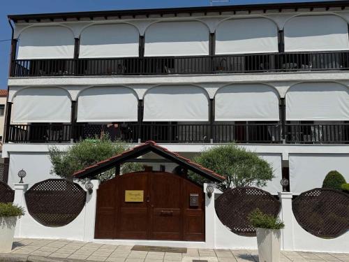 a building with a wooden door and a balcony at Amaryllis Luxury Rooms in Platamonas