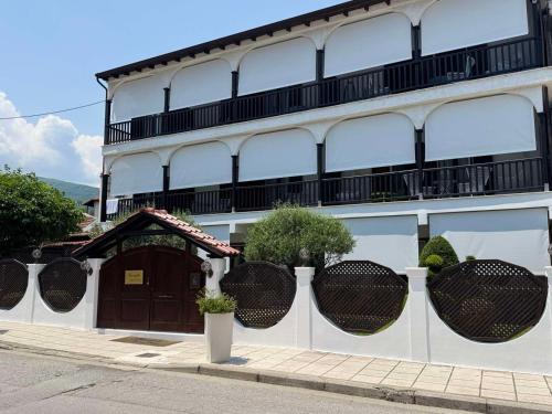 a white building with a balcony on top of it at Amaryllis House in Platamonas