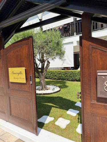 an open door with a sign on it next to a tree at Amaryllis House in Platamonas
