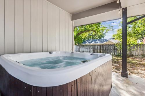 a bath tub in a room with a large window at HotTub, Cinema & Games in a Quiet Neighborhood in Wichita