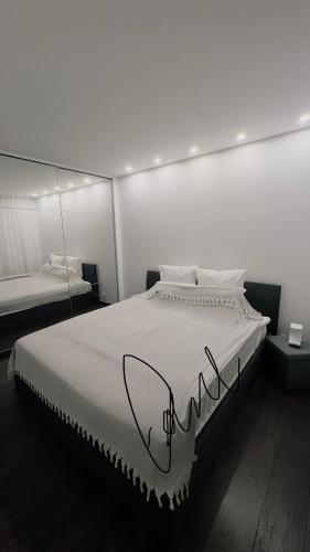 une chambre avec un grand lit blanc avec un miroir dans l'établissement Appartement une chambre, à Cannes