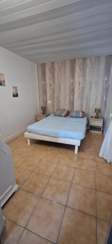- une chambre avec un lit et un mur en bois dans l'établissement Appartement St montan, à Saint-Montan