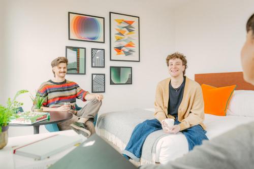 two men sitting on a couch in a living room at The SPACE To Stay, St Andrews in St. Andrews