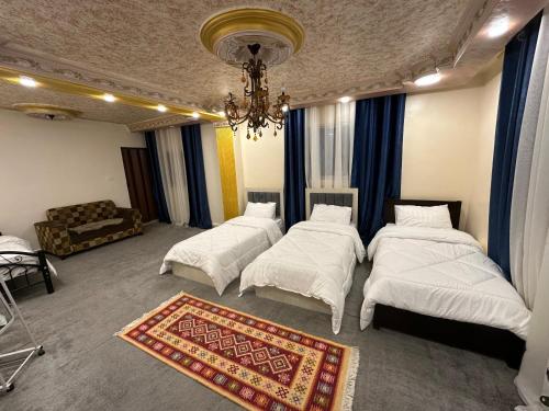 a room with three beds and a chandelier at Aseel bedoul in Petra