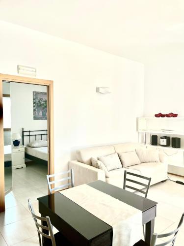 a living room with a table and a couch at Polignano Villa with Jacuzzi, Garden & Parking in Polignano a Mare