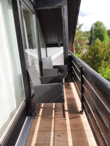 a balcony with three chairs on a house at Studio mit Sonnenuntergang plus Wlan gratis in Nürnberg