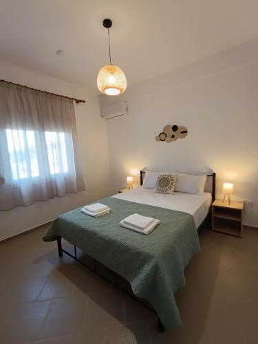 a bedroom with a bed with a green blanket at 3B House in Nea Vrasna
