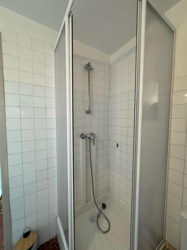 une douche avec une porte vitrée dans une salle de bain dans l'établissement Le Barcarès avec vue panoramique sur la mer, au Barcarès