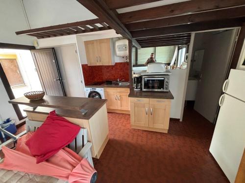 une cuisine avec des armoires en bois et un homme dans le miroir dans l'établissement Le Barcarès avec vue panoramique sur la mer, au Barcarès