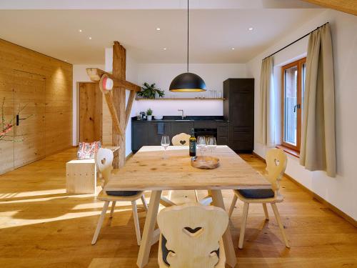 a dining room with a wooden table and chairs at Moierhof in Gstadt am Chiemsee