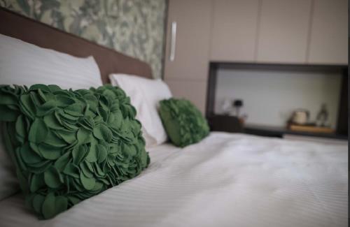 a bed with a green pillow on top of it at Una Meryland in Kulen Vakuf