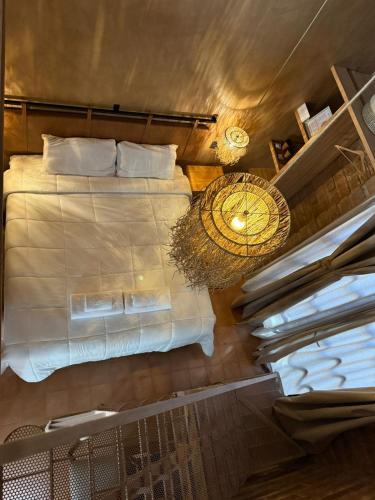 a bedroom with a bed with white sheets and a fan at Mitu in Purmamarca