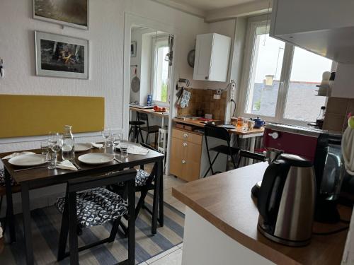 une cuisine avec une table et des chaises dans une pièce dans l'établissement Villa Auguste chambre lumineuse, à Quimper