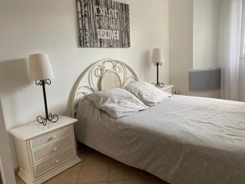 una camera da letto con un letto bianco e due lampade di Dépendance paisible a Ventenac-Cabardès