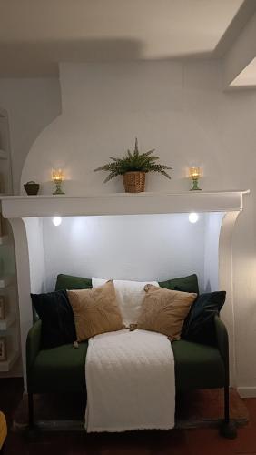 a green couch with pillows on it in a room at Une bulle de bien être au rendez vous in Pexiora