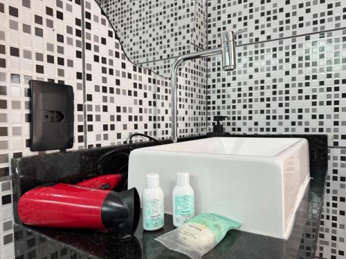a bathroom with a sink and a red bottle on a counter at BayShore Loft in Cabo Frio