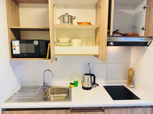 a kitchen with a sink and a microwave at Conectividad & Comodidad in Santiago