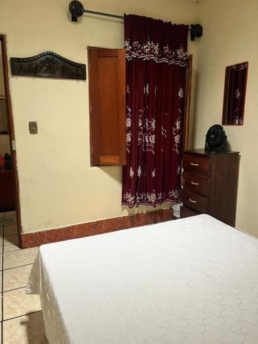 a bedroom with a bed and a red curtain at Jireh guesthouse in Antigua Guatemala