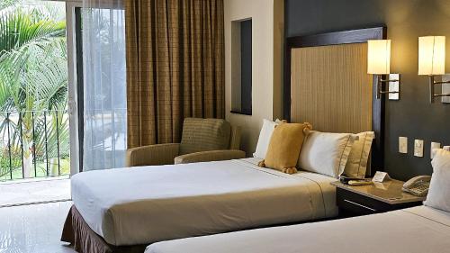 a hotel room with two beds and a window at Casa Francisco in Cuernavaca