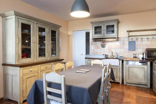 une cuisine avec une table et des chaises dans une cuisine dans l'établissement Gîte de France Gîte les pierres bleues 2 épis - Gîte de France 2 personnes MAE-4011, à Uzerche