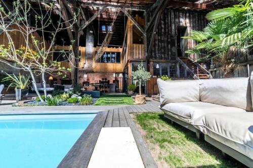 - un salon extérieur avec un canapé et une piscine dans l'établissement Gîte de France La cachette 5 épis - Gîte de France 10 personnes MAE-1313, à Brive-la-Gaillarde