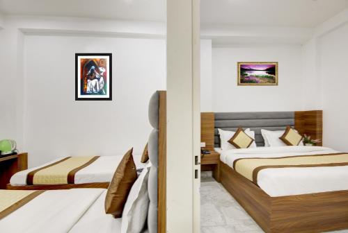 a hotel room with two beds with white walls at Hotel S B Inn Near New Delhi railway Station Paharganj in New Delhi