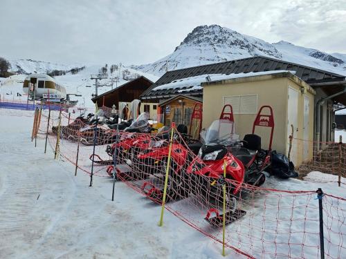 a group of snowmobiles parked next to a building in the snow at Hameau Des Aiguilles vue sur pistes in Albiez-Montrond
