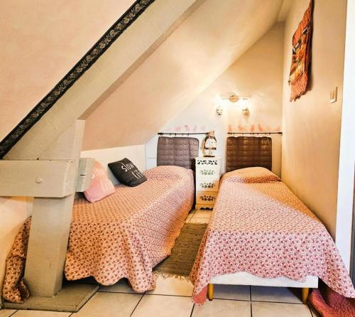 two beds in a room with an attic at Gîte de France Les saulieres 3 épis - Gîte de France 10 personnes MAE-1323 in Monceaux-sur-Dordogne