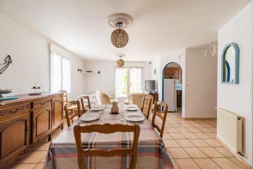 een keuken en eetkamer met een tafel en stoelen bij Maison familiale proche mer - Etables-sur-Mer in Binic