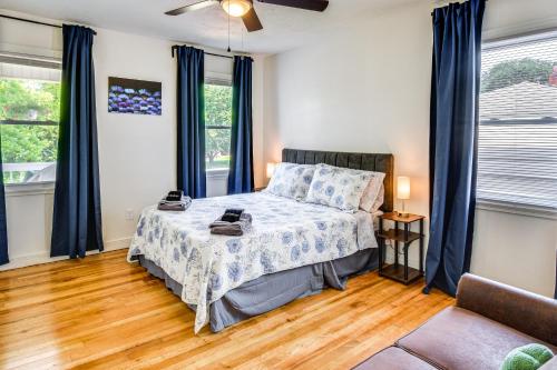 a bedroom with a bed with blue curtains at 4 Mi to Clemson Pet-Friendly Seneca Cottage in Seneca