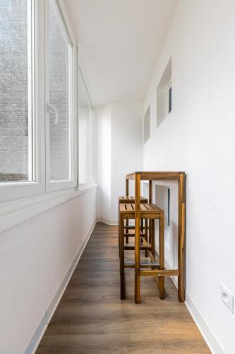 - un tabouret en bois dans une chambre avec fenêtre dans l'établissement Studio cosy Krutneau, à Strasbourg