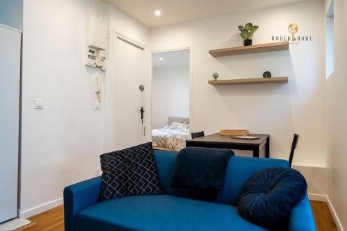 un salon avec un canapé bleu et une table dans l'établissement Le Henri - Cozy metro 5 min à pied du métro, Paris direct, à Maisons-Alfort