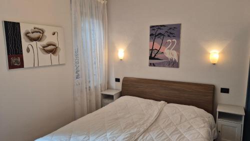 a bedroom with a bed and two pictures on the wall at Casa vacanza Auronzo in Auronzo di Cadore