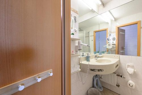 a bathroom with a sink and a mirror at Blue Wellness Pools Saunas Appartement with Alpine view Balcony in Sankt Englmar